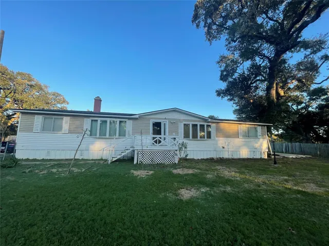 a front view of a house with a yard and trees