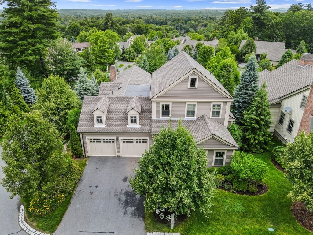 an aerial view of a house with a yard and large trees