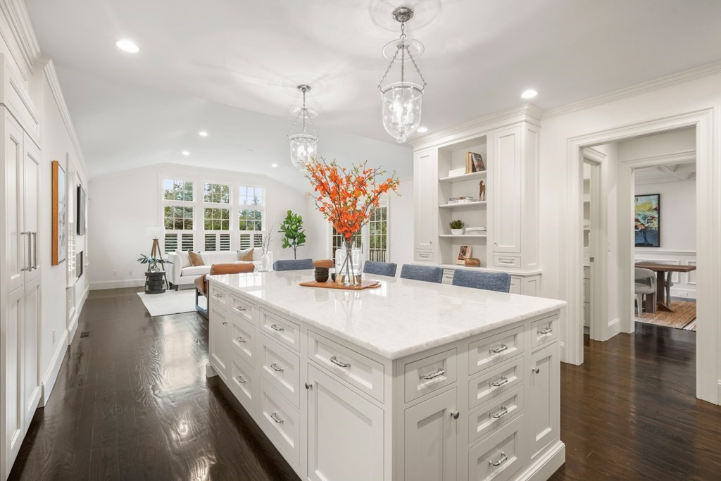 29 Pine Summit Circle, Unit 29 Weston, MA 02493 - Photo 10 of 30 a large kitchen with kitchen island a stove a chandelier a dining table and chairs with wooden floor