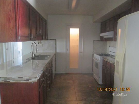 227 South Springside Street Ridgecrest, CA 93555 - Photo 7 of 22 a kitchen with a sink a stove and cabinets