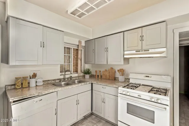 a kitchen with granite countertop white cabinets and white appliances