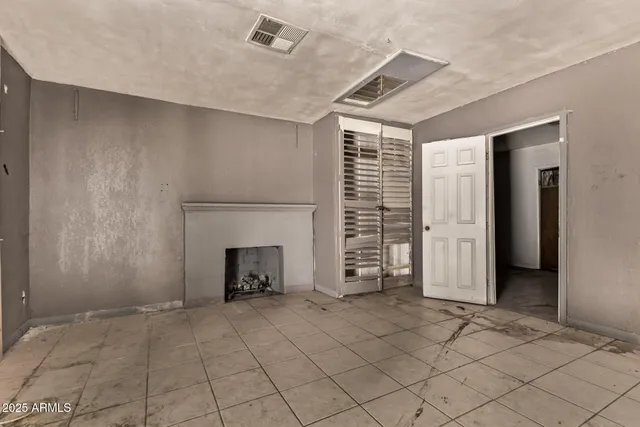 an empty room with fireplace and window
