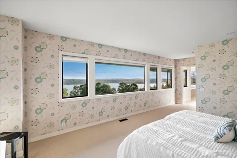 a bedroom with a large window and a balcony view