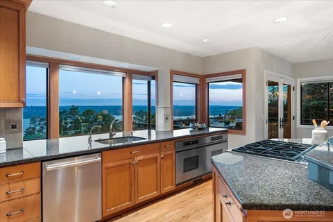 a large kitchen with kitchen island a large window in it