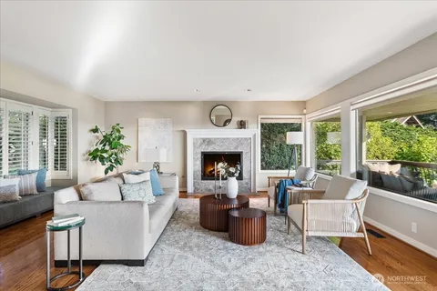 a living room with furniture a fireplace and a large window