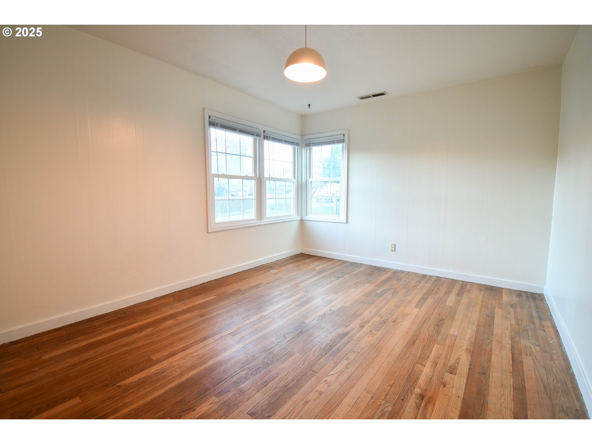1731 Southeast Hamilton Street Roseburg, OR 97470 - Photo 13 of 23 an empty room with wooden floor and windows