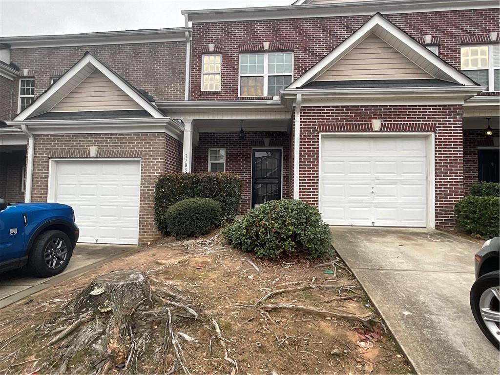 2555 Flat Shoals Road, Unit 1703 Atlanta, GA 30349 - Photo 1 of 26 a front view of a house with a yard and garage