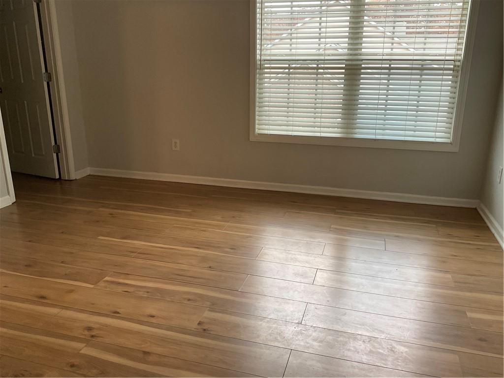 2555 Flat Shoals Road, Unit 1703 Atlanta, GA 30349 - Photo 11 of 26 a view of an empty room with wooden floor and a window