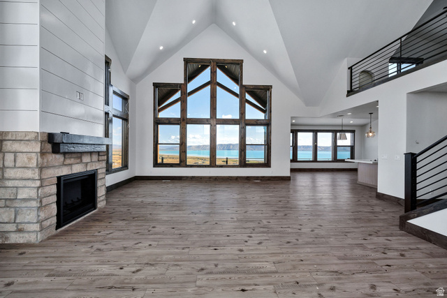 300 Knoll Loop, Unit 227 Fish Haven, ID 83287 - Photo 8 of 56 Unfurnished living room featuring a high ceiling, a stone fireplace, wood finished floors, and recessed lighting