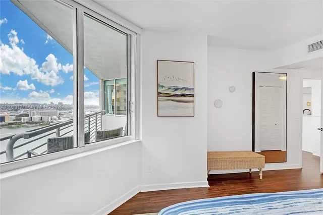 a room with wooden floor and a large window