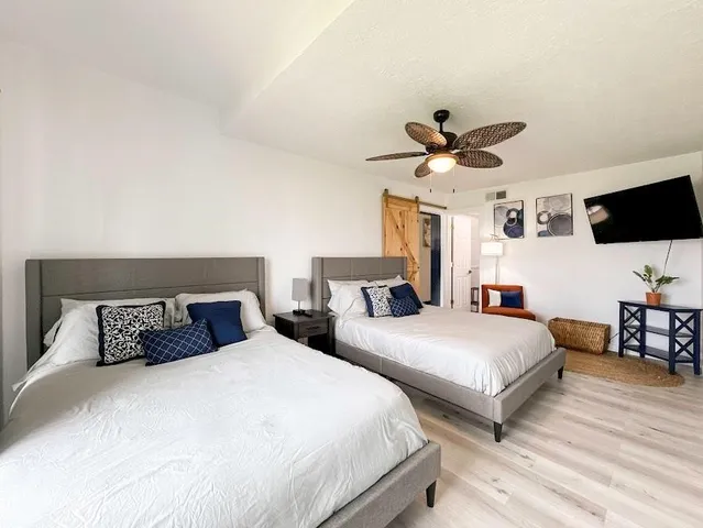 a bedroom with two beds and a chandelier