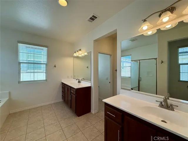 a large bathroom with a granite countertop tub a sink a mirror and a shower