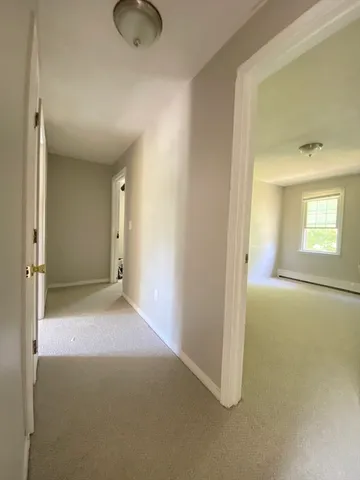 an empty room with a window and closet area