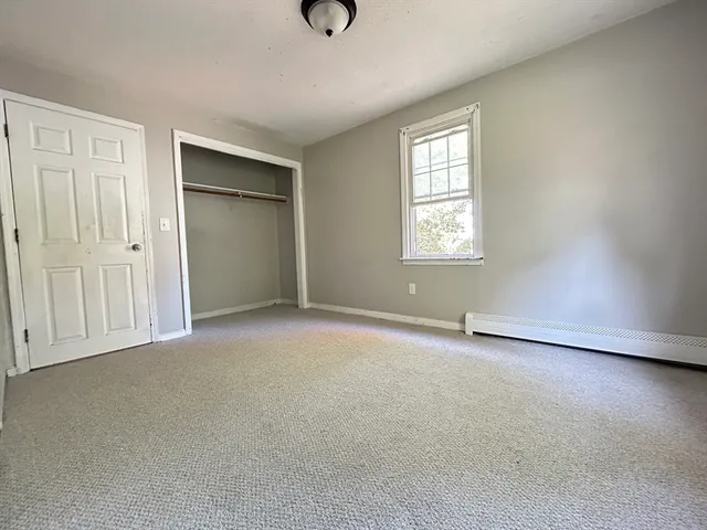 an empty room with windows and closet