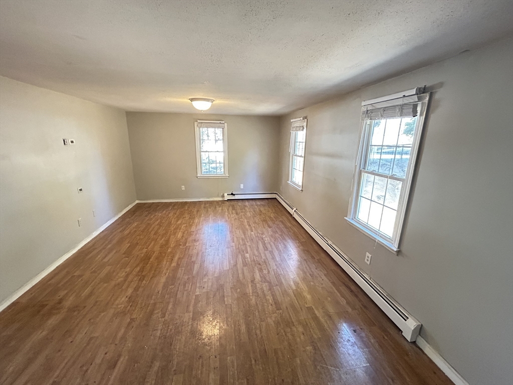 266 Massasoit Road Worcester, MA 01604 - Photo 22 of 26 an empty room with wooden floor and windows