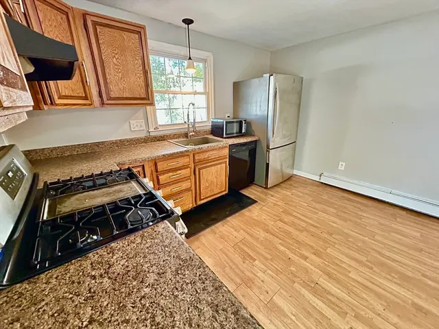 a kitchen with stainless steel appliances granite countertop a stove a sink and a refrigerator