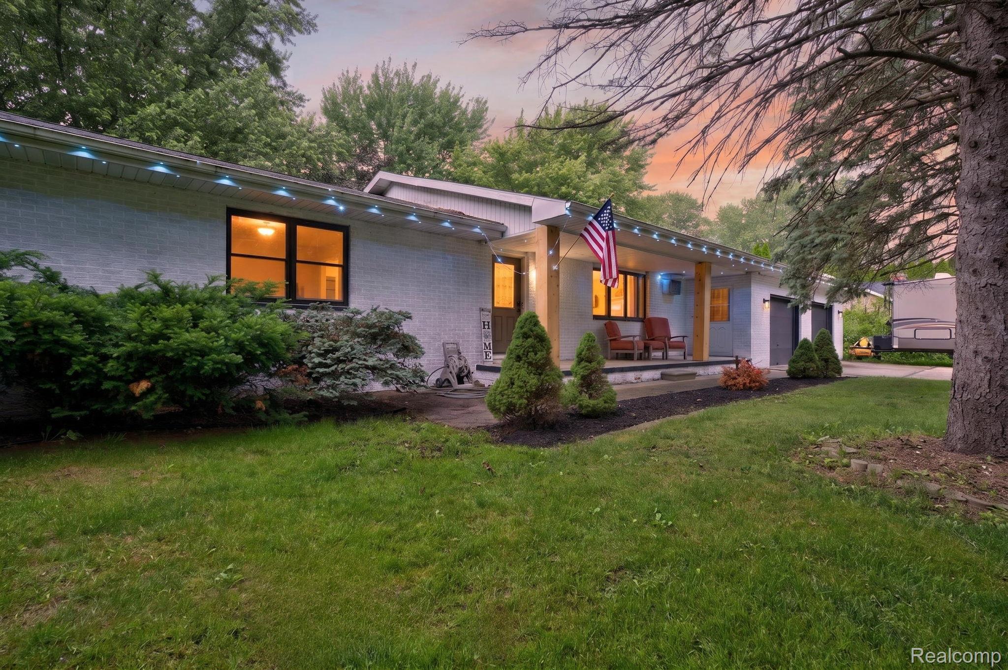 5330 Sheridan Road Saginaw, MI 48601 - Photo 1 of 50 White brick exterior featuring a covered entry porch with recessed lighting and a wood-toned column