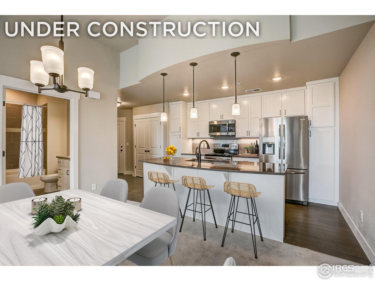 a kitchen with stainless steel appliances kitchen island granite countertop a dining table chairs and a refrigerator