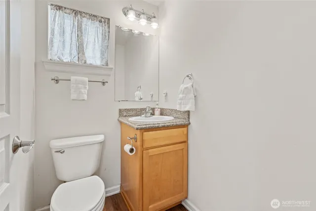 a bathroom with a toilet a sink and mirror