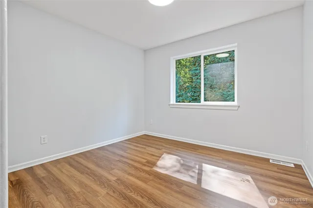 a view of a room with wooden floor and window