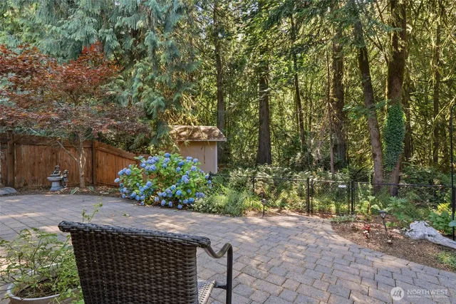 a pathway of a house with a yard and wooden fence