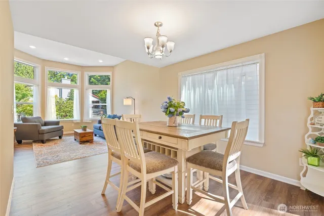 a dining room with furniture a chandelier and wooden floor