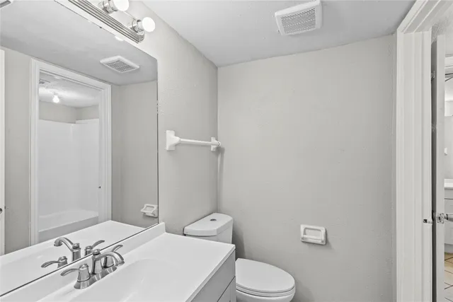 a bathroom with a sink a toilet and shower curtain