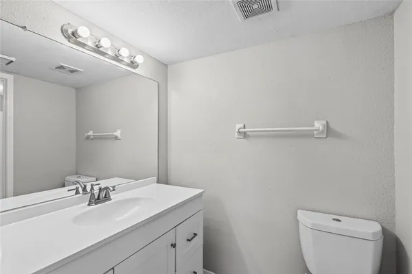 a bathroom with a sink vanity granite and toilet