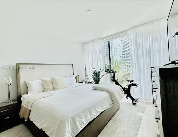 a bedroom with a bed and large window