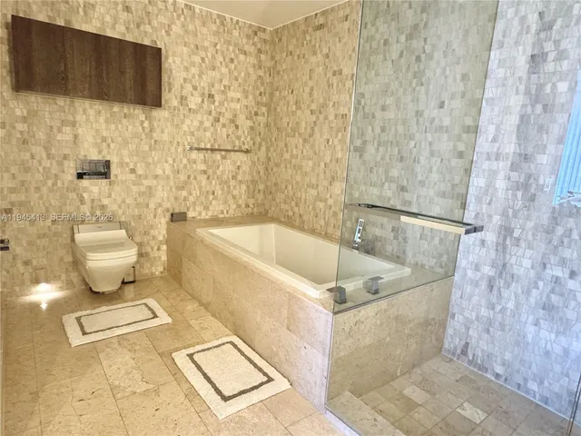 a white bath tub sitting next to a white toilet