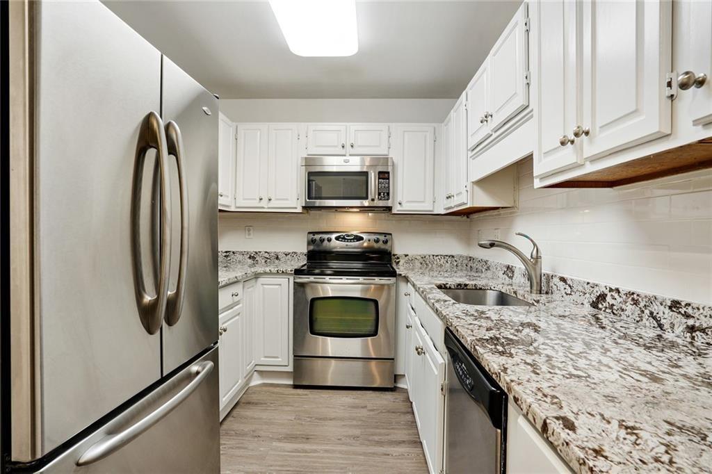 3203 Lenox Road Northeast, Unit 6 Atlanta, GA 30324 - Photo 6 of 27 a kitchen with stainless steel appliances granite countertop a stove a refrigerator and a sink