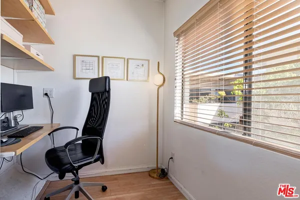 a view of a workspace with furniture and a window