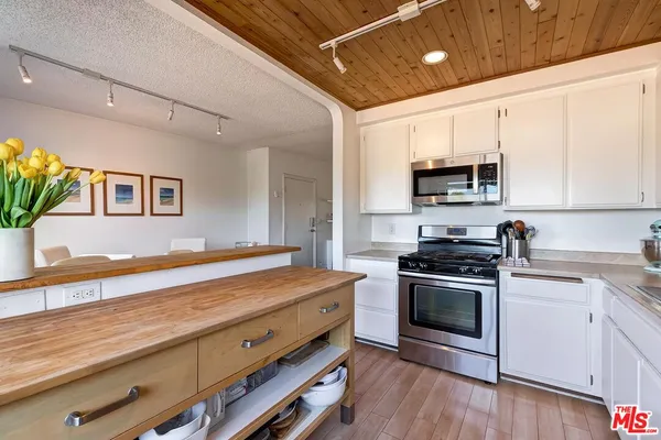 a kitchen with stainless steel appliances a stove microwave and sink