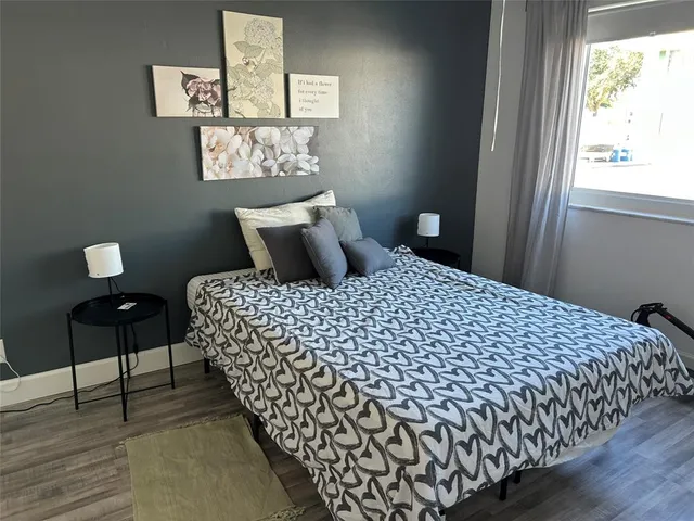 a large bed sitting in a bedroom next to a window