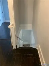 an empty room with wooden floor closet and windows