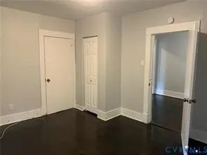 an empty room with wooden floor and closet