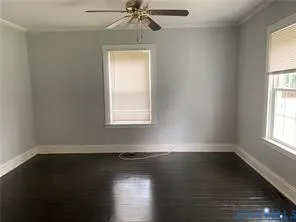 an empty room with wooden floor windows and window