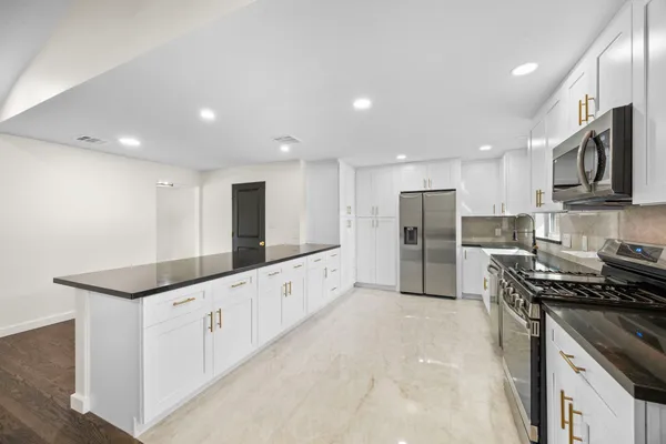 a kitchen with stainless steel appliances a stove a sink and a refrigerator