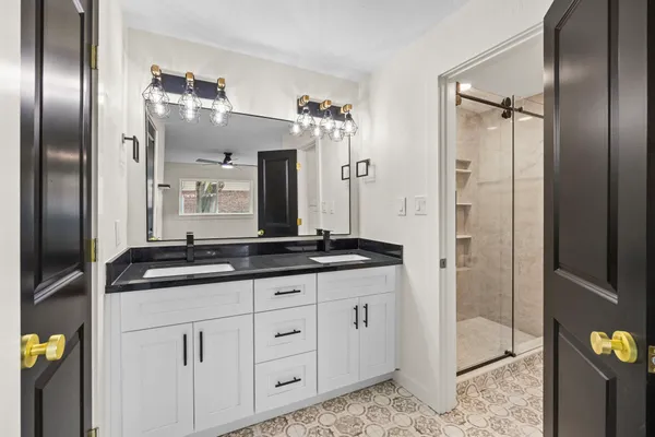 a bathroom with double sink and a mirror