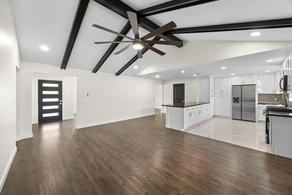 a view of a room with wooden floor and a ceiling fan