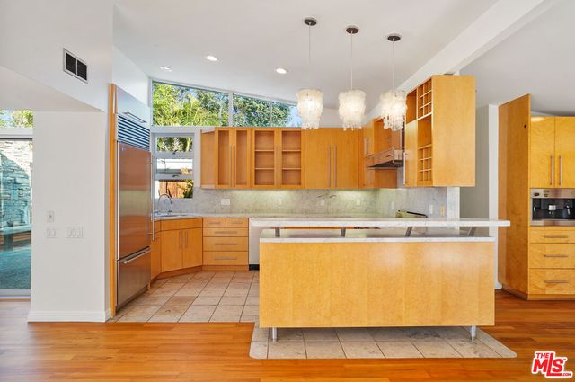 a kitchen with stainless steel appliances granite countertop a stove a sink and a refrigerator
