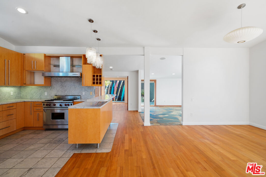 30725 Manzano Drive Malibu, CA 90265 - Photo 22 of 51 a kitchen with stainless steel appliances granite countertop a stove top oven a sink dishwasher and a refrigerator with wooden floor