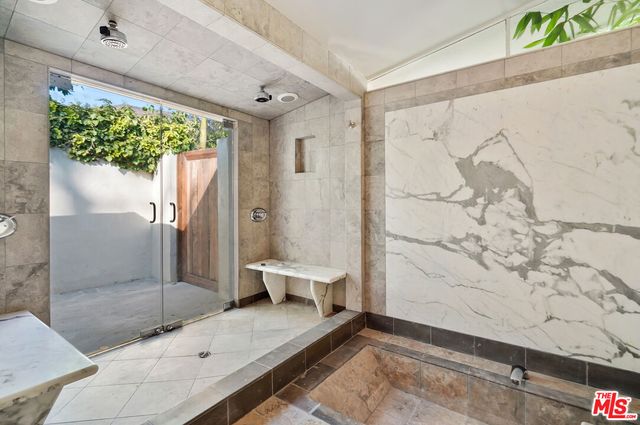 a bathroom with a granite countertop toilet a shower and a mirror