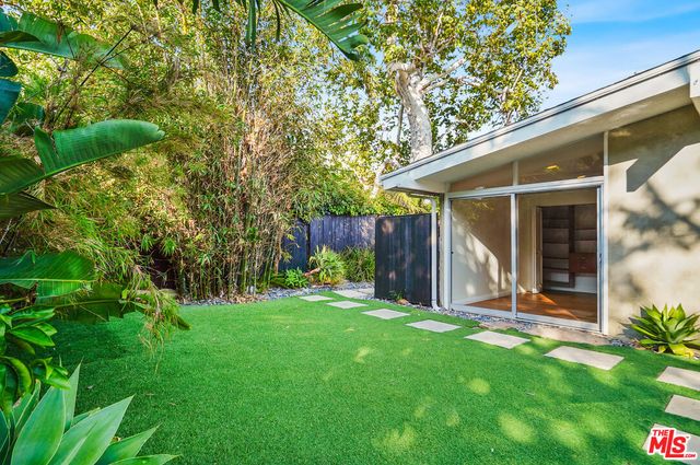 a view of a house with backyard and a tree