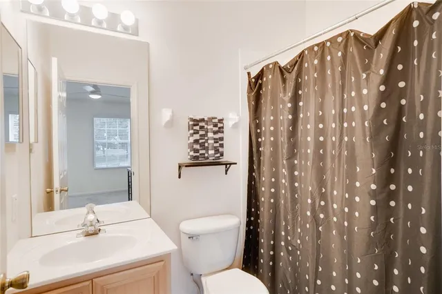 a bathroom with a sink mirror vanity and toilet