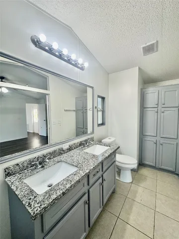 a bathroom with a granite countertop sink and a mirror
