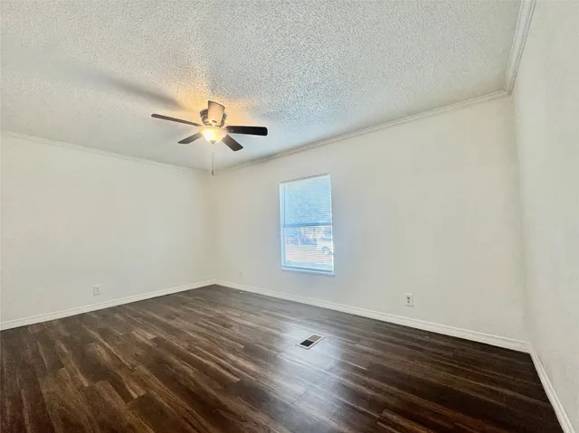 an empty room with wooden floor and ceiling fan