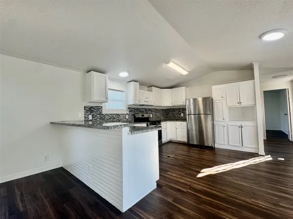 a kitchen with stainless steel appliances a refrigerator and a stove top oven