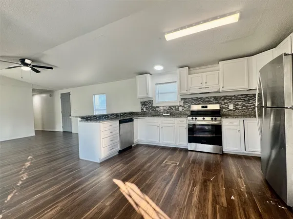a kitchen with wooden floors and white appliances