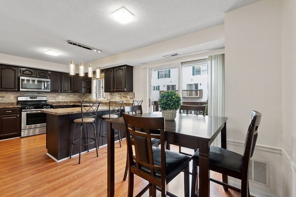 25 Century Way, Unit 25 Gardner, MA 01440 - Photo 15 of 34 a view of a dining room with furniture wooden floor and a kitchen view